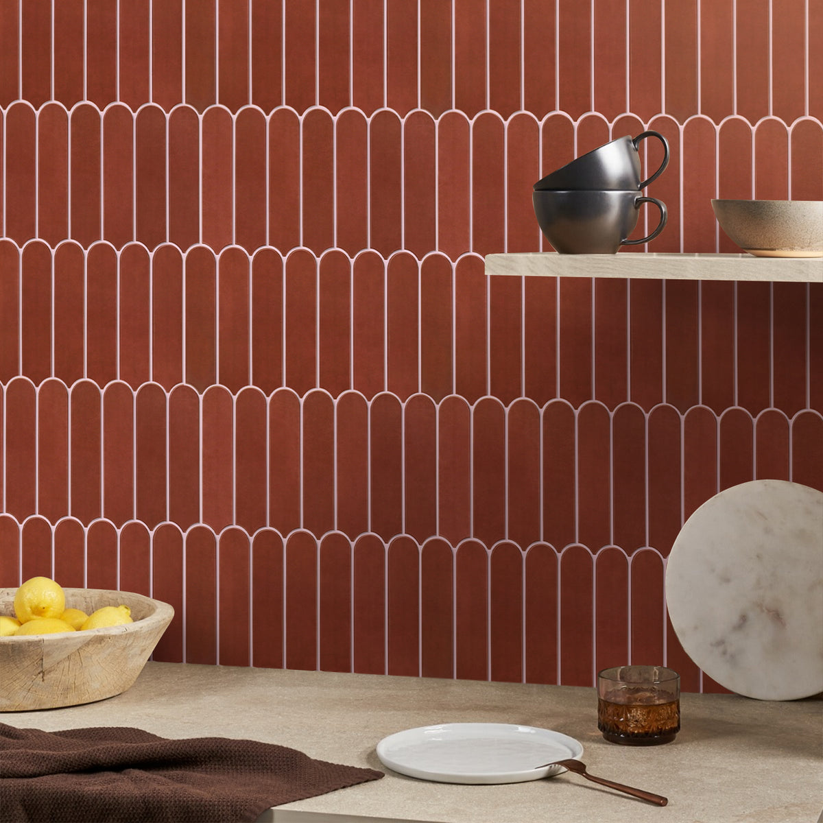 Decorative wall with red tiles and a table with ceramic items.